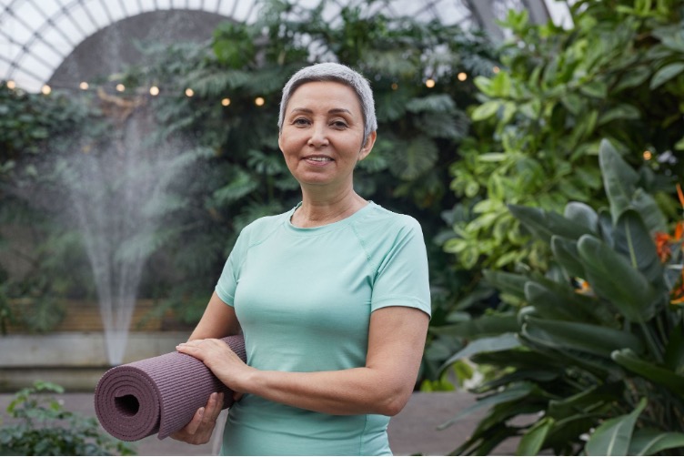 Woman holding a yoga mat and preparing for exercise to regulate your nervous system through movement.